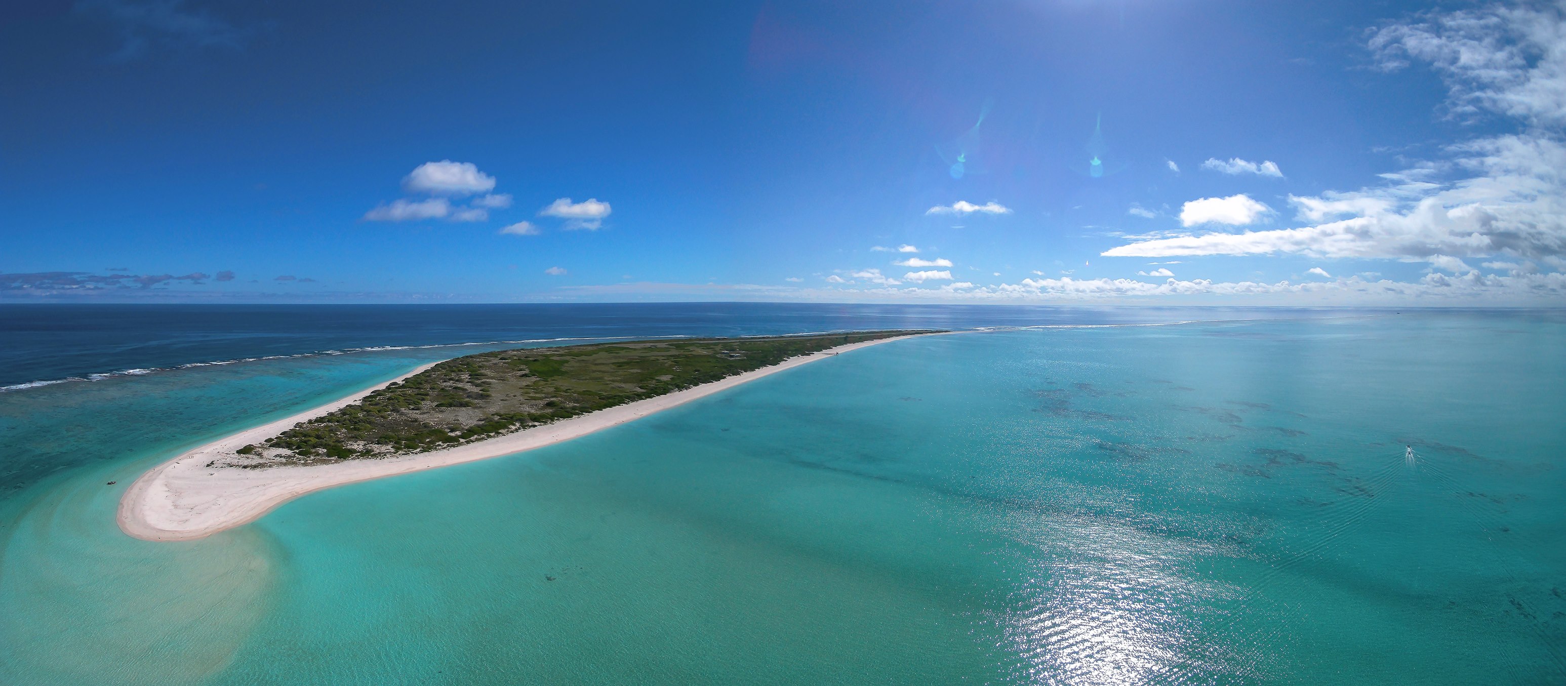 A low lying Hawaiian atoll with crystal clear waters, sandy beaches, and vegetation